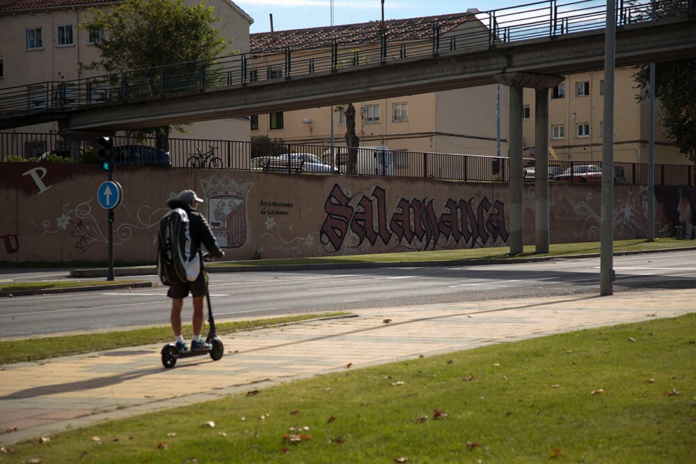 Un joven circula con un patinete por la avenida de Saavedra y Fajardo.